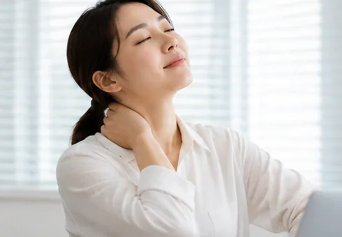 눈을 감고 목 뒤에 손을 얹은 여성