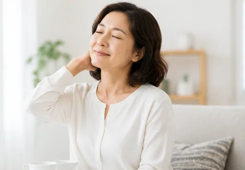 눈을 감고 목 뒤에 손을 얹은 중년 여성